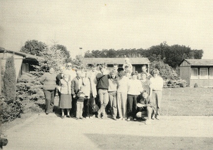 a group photo in front of bungalows